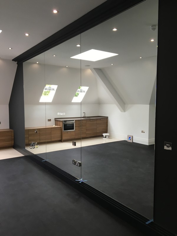 Frameless glass partition in loft conversion by St Albans glaziers